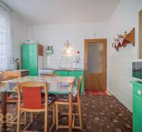 Küche in einem Einfamilienhaus mit Retro-Möbeln, Esstisch und Küchenausstattung.