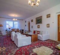 Wohnzimmer in einem Einfamilienhaus mit Teppich, Sofas und Tisch, ausreichend für ein bequemes Entspannen.