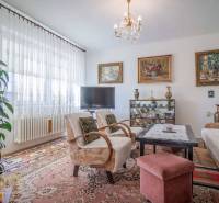 Wohnzimmer in einem Einfamilienhaus mit Sofa, Fernseher und Bildern an den Wänden.