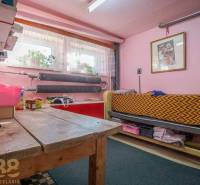 Ein Zimmer in einem Einfamilienhaus mit rosa Wänden, einem Holztisch und einem Bett.