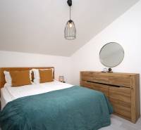 Schlafzimmer in einer Ferienwohnung mit Bett, Holzkiste, Spiegel und Lampe.