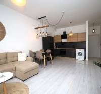 Ferienwohnung mit Holzboden, Ecksofa und moderner Küche.