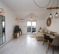 Wohnzimmer in einer Ferienwohnung mit Holzboden und großem Spiegel.