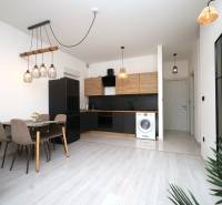 Küche in einer Ferienwohnung mit Esstisch und Boden in Holzoptik.