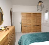 Schlafzimmer im Ferienapartment mit Holzdekor, Spiegel und Dekorationen.