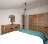 Für eine Ferienwohnung sind typische Schränke und eine Kommode mit Holzdekor und Spiegel.