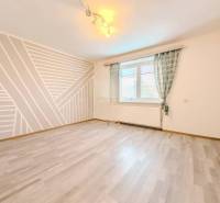 Ein Zimmer in einem Einfamilienhaus mit geometrischer Malerei und einem Boden in Holzoptik.