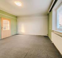 Innenraum eines Einfamilienhauses mit bunten Wänden, Teppichboden und einem Fenster mit Jalousien.