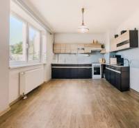 Küche in einem Einfamilienhaus mit Holzboden und großem Fenster.