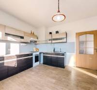 Eine Küche in einem Einfamilienhaus mit einem Holzboden und modernen Küchenzeilen.