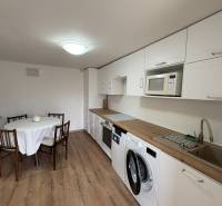 Küche in einer Einzimmerwohnung mit Holzboden und Esstisch.