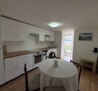 Küche in einer Einzimmerwohnung mit Holzboden und Esstisch.