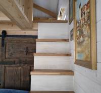 Holztreppe im Einfamilienhaus, Wände mit hängenden Bildern.