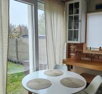 Essbereich in einem Einfamilienhaus mit Holzboden, Ziegelwand und großen Fenstern.