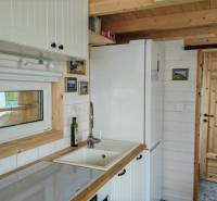 Eine Küche in einem Einfamilienhaus mit weißen Möbeln und Holzelementen.