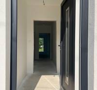 Ein Flur in einem Einfamilienhaus mit weißen Wänden, Blick in den Garten.