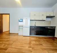 Küche mit Küchenzeile und Geräten in einer 2-Zimmer-Wohnung mit Holzboden.