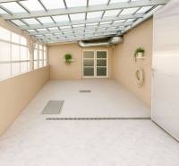 Überdachte Terrasse mit Pflanzen, Türen und Kanalisation im Gebäude.