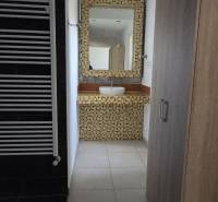 Badezimmer mit Waschbecken, Mosaik und Handtuchhalter, Boden mit Holzdekor.