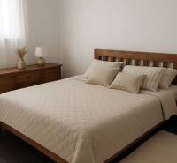 Schlafzimmer mit Holzmöbeln, Bett und dekorativen Kissen, gedämpfte Farben.