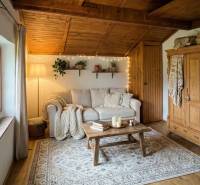 Ein gemütliches Wohnzimmer in einer Hütte mit einem Sofa, Holzelementen und dekorativen Lichtern.