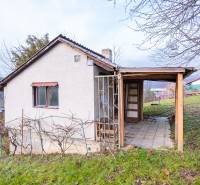 Eine Hütte in Prešov mit Holzkonstruktion und einem Weinberg auf einem grasbewachsenen Hügel.