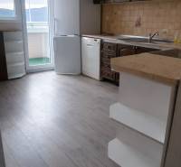 Küche in einer 3-Zimmer-Wohnung mit Holzboden, weißem Kühlschrank und Geschirrspüler.