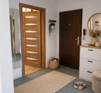 3-Zimmer-Wohnung mit warmer Beleuchtung, Holztüren und weißen Möbeln.