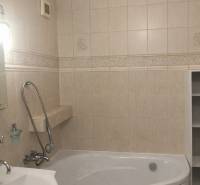 Badezimmer einer 3-Zimmer-Wohnung mit Badewanne und beigefarbenen Wandfliesen.