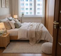 Schlafzimmer mit Bett, Teppich und Holzboden in einer 3-Zimmer-Wohnung.