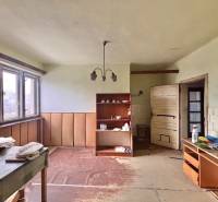 Izba in einem Einfamilienhaus mit Möbeln, Regalen und einem großen Fenster.