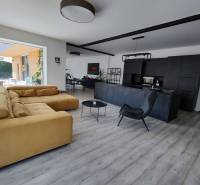 Wohnzimmer in einem Einfamilienhaus mit Holzboden und bequemer Couch.