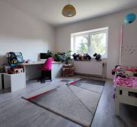 Kinderzimmer in einem Einfamilienhaus mit Holzboden, Schreibtisch und Spielzeug.