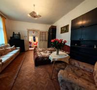 Wohnzimmer in einem Einfamilienhaus mit Sofas, Fernseher und Boden in Holzoptik.