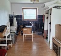 Ein Zimmer in einem Einfamilienhaus mit einem Boden in Holzoptik und vielen Kisten.