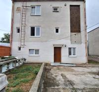 Ein Einfamilienhaus in Zacharovce mit einer einfachen Fassade, Fenstern und einer Außentreppe.
