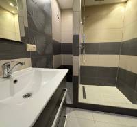 Badezimmer in einer 3-Zimmer-Wohnung mit modernen Fliesen und einer Duschkabine.