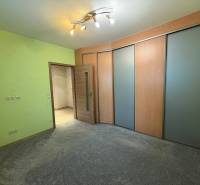 Ein Zimmer in einer 3-Zimmer-Wohnung mit einer farbigen Wand, einem Schrank und heller Beleuchtung.