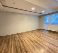 Wohnzimmer in einer 3-Zimmer-Wohnung mit Holzboden und großem Fenster.