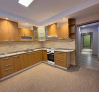 Küche in einer 3-Zimmer-Wohnung mit Holzdekor und eingebauten Geräten.