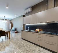 Küche in einer 3-Zimmer-Wohnung mit Marmorboden und hellen Möbeln.