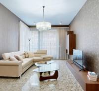 Wohnzimmer in einer 3-Zimmer-Wohnung mit beigem Sofa, Glastisch und Fernseher.