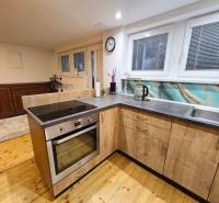 Küche in einer Einzimmerwohnung mit Spüle, Elektroherd und Holzboden.