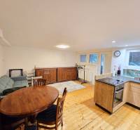 Wohnzimmer in einer Einzimmerwohnung mit Holzboden, Sofa und Esstisch.