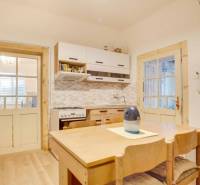 Eine Küche in einem Einfamilienhaus mit Holzmöbeln und einem Boden in Holzoptik.