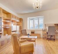 Wohnzimmer mit Holzmöbeln, Boden mit Holzdekor, Kronleuchter.