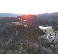 Sonnenuntergang in Krpáčovo über den Wäldern, dem See und den Gebäuden in der Straße Krpáčovo.
