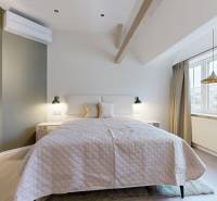 Helles Schlafzimmer mit bequemem Bett und Fenster in einer 4-Zimmer-Wohnung.