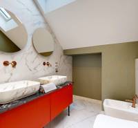 Badezimmer mit Waschbecken auf einer Marmorplatte und grünen Wänden in einer Vierzimmerwohnung.