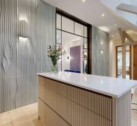 Innenraum einer 4-Zimmer-Wohnung mit Designerwand, hellen Möbeln und Blumen auf dem Tisch.